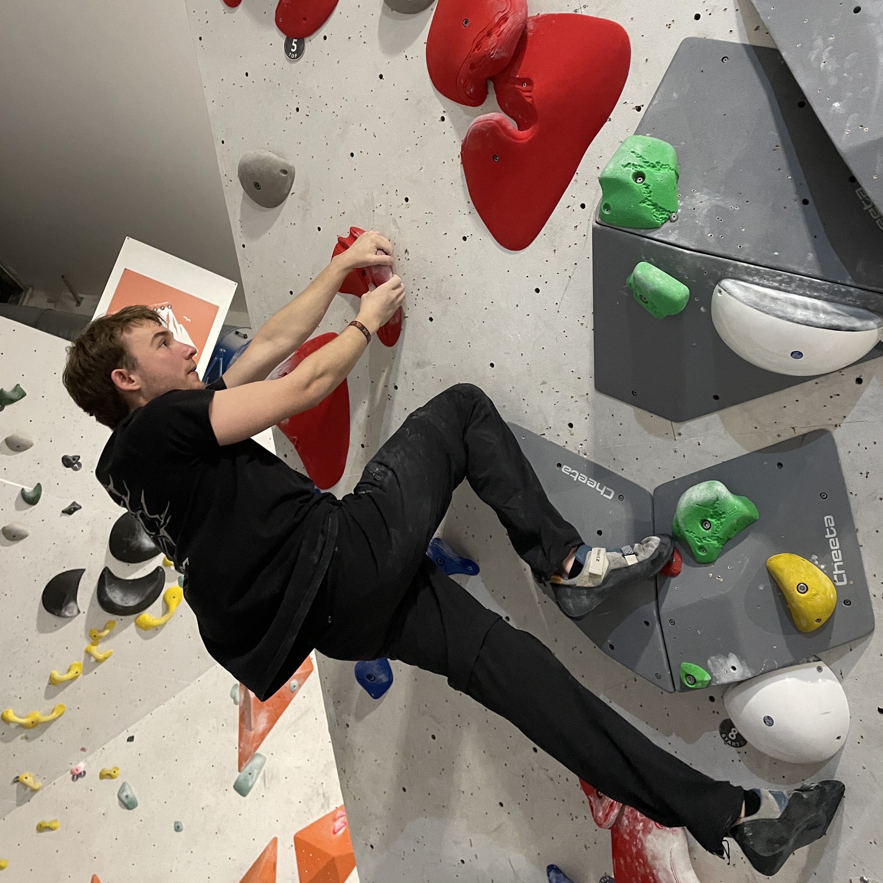 Erik Vautrin beim Bouldern als Teil eines aktiven Rückentrainings. Bouldern stärkt die Rückenmuskulatur, verbessert die Haltung und fördert die Beweglichkeit. Beispiel für eine effektive und spaßige Aktivität zur Förderung der Rückengesundheit.